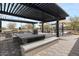 Outdoor kitchen and dining area featuring a stone table, built-in grill, and pergola in a shared outdoor space at 4060 E French Trotter St, San Tan Valley, AZ 85140
