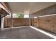 Spacious covered patio area showing brick walls, a gate, and concrete flooring at 600 S Dobson Rd # 67, Mesa, AZ 85202