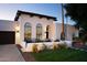 An elegant home boasts a Spanish tile roof, arched windows, and a cozy front patio at 8332 E San Simon Dr, Scottsdale, AZ 85258