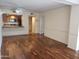 Open living room featuring wood floors and a view of the kitchen with a breakfast bar at 10330 W Thunderbird Blvd # C-228, Sun City, AZ 85351
