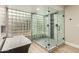 Bathroom featuring a glass shower with gray tile, a soaking tub and a unique brick wall at 10775 N 101St St, Scottsdale, AZ 85260