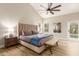 Bright bedroom featuring vaulted ceilings, a ceiling fan, and access to a pool via a glass door at 10775 N 101St St, Scottsdale, AZ 85260