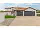 Charming two-story home featuring a tiled roof, gray garages, and well-manicured front yard at 10775 N 101St St, Scottsdale, AZ 85260