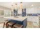 Open kitchen with a quartz island, stainless steel appliances, and designer pendant lighting at 10775 N 101St St, Scottsdale, AZ 85260