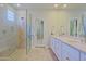 Modern bathroom with a glass-enclosed shower, double vanity, and neutral tile flooring at 32868 N 69Th St, Scottsdale, AZ 85266
