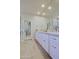 Bathroom featuring dual sinks, a large mirror, a door with mirrors and neutral tile flooring at 32868 N 69Th St, Scottsdale, AZ 85266