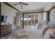 Bedroom with a four-poster bed, ceiling fan, and an open window to a patio with desert plants at 32868 N 69Th St, Scottsdale, AZ 85266