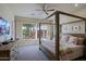 Spacious bedroom with a four-poster bed and a view of the outdoor patio and desert landscaping at 32868 N 69Th St, Scottsdale, AZ 85266