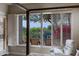 A bedroom view to patio with desert landscaping, featuring cacti, trees, and patio furniture for relaxation at 32868 N 69Th St, Scottsdale, AZ 85266