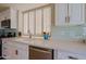 Modern kitchen counter with a stainless steel dishwasher, sink, and blue tile backsplash at 32868 N 69Th St, Scottsdale, AZ 85266