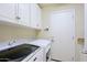 Laundry room features front loading washer and dryer and white shaker cabinets at 32868 N 69Th St, Scottsdale, AZ 85266