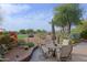 Charming patio with dining set, vibrant flowers, and beautiful golf course views at 32868 N 69Th St, Scottsdale, AZ 85266