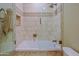 Tiled bathtub and shower with decorative trim, a rainfall showerhead, and built-in storage at 32868 N 69Th St, Scottsdale, AZ 85266