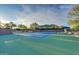 Well-maintained tennis court with mountain views, surrounded by mature trees and lush desert landscaping at 32868 N 69Th St, Scottsdale, AZ 85266