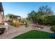 Beautifully landscaped backyard with pergola covered outdoor living area and green artificial turf at 6887 E Hacienda La Colorada Dr, Gold Canyon, AZ 85118