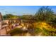 A relaxing backyard with an outdoor fireplace, comfortable seating, and well-maintained landscaping in the evening at 6887 E Hacienda La Colorada Dr, Gold Canyon, AZ 85118