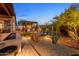 Expansive backyard with water feature, outdoor kitchen, pergola, and lush landscaping at 6887 E Hacienda La Colorada Dr, Gold Canyon, AZ 85118