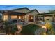 Inviting backyard featuring a covered patio, lush landscaping, a fire pit, and a charming outdoor seating area at 6887 E Hacienda La Colorada Dr, Gold Canyon, AZ 85118
