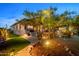 Beautifully landscaped backyard featuring mature trees, custom lighting, and outdoor spaces at 6887 E Hacienda La Colorada Dr, Gold Canyon, AZ 85118