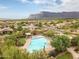 Aerial view of a community pool with lounge chairs, cabanas, and mountain views at 6887 E Hacienda La Colorada Dr, Gold Canyon, AZ 85118