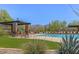 Serene community pool with shaded seating and well-maintained artificial turf at 6887 E Hacienda La Colorada Dr, Gold Canyon, AZ 85118