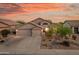 Stunning home exterior with a three-car garage, desert landscaping and dramatic sunset sky at 6887 E Hacienda La Colorada Dr, Gold Canyon, AZ 85118