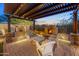Inviting outdoor living area featuring a stone fireplace, comfortable seating, and a pergola at 6887 E Hacienda La Colorada Dr, Gold Canyon, AZ 85118