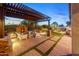 Beautiful outdoor living space with fireplace, pergola, seating, and manicured lawn at 6887 E Hacienda La Colorada Dr, Gold Canyon, AZ 85118