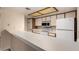 Kitchen features white appliances and cabinets, tile flooring, and a pass-through counter at 1021 S Greenfield Rd # 1194, Mesa, AZ 85206