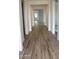 Inviting hallway featuring elegant wood-look tile flooring leading to sunlit rooms at 14742 W Lariat Trl, Surprise, AZ 85387