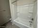 A clean bathroom featuring a shower-tub combination, storage shelves, and neutral color palette at 3021 N 306Th Ln, Buckeye, AZ 85396