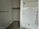 Clean bathroom featuring a bright shower with built-in shelves and hanging rod for storage at 3021 N 306Th Ln, Buckeye, AZ 85396