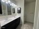 Bathroom featuring a double sink vanity with modern fixtures, mirrors and tiled floors at 3021 N 306Th Ln, Buckeye, AZ 85396
