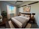 Cozy bedroom featuring a wood-frame bed, soft rug, stylish lamps and a window with natural light at 3021 N 306Th Ln, Buckeye, AZ 85396