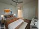 Staged bedroom with white walls, a modern bed, and a large window letting in natural light at 3021 N 306Th Ln, Buckeye, AZ 85396