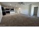 Spacious living room area featuring neutral carpet and an open floor plan leading into the kitchen at 3021 N 306Th Ln, Buckeye, AZ 85396