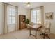 Bright home office featuring a wooden desk, ceiling fan, and two large windows at 4088 E Jude Ln, Gilbert, AZ 85298