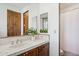 Bathroom featuring a sink with white tile countertop, wooden cabinets, and a decorative plant next to the mirror at 7701 E Golden Eagle Cir, Gold Canyon, AZ 85118