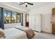 Bright bedroom with a ceiling fan, large window offering an outdoor view and a beautiful, rustic cabinet at 7701 E Golden Eagle Cir, Gold Canyon, AZ 85118