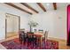 Formal dining room with exposed beams, a rustic wood table and accent rug at 7701 E Golden Eagle Cir, Gold Canyon, AZ 85118