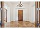 Elegant foyer with tiled flooring and a chandelier, featuring an arched wooden front door at 7701 E Golden Eagle Cir, Gold Canyon, AZ 85118