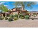Charming home exterior with desert landscaping, a stone chimney, and a tile roof at 7701 E Golden Eagle Cir, Gold Canyon, AZ 85118
