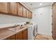 Functional laundry room with ample cabinet storage, a utility sink, and modern washer and dryer at 7701 E Golden Eagle Cir, Gold Canyon, AZ 85118