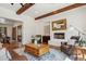 Bright living room with hardwood floors, fireplace, an area rug, and exposed beam ceilings at 7701 E Golden Eagle Cir, Gold Canyon, AZ 85118