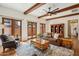 Cozy living room with exposed beam ceilings, leather furniture, and doors to the outside patio at 7701 E Golden Eagle Cir, Gold Canyon, AZ 85118