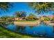 Scenic view of a pond surrounded by lush landscaping and charming residential buildings in the background at 7701 E Golden Eagle Cir, Gold Canyon, AZ 85118