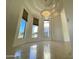 Bright dining room with travertine tile, tray ceilings, designer chandelier, and big windows with exterior views at 9943 E Island Cir, Scottsdale, AZ 85258