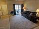 Comfortable living room featuring neutral carpet, sofa, side tables, and sliding glass doors to outdoor patio at 10136 E Southern Ave # 2048, Mesa, AZ 85209