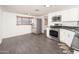 Bright kitchen featuring stainless steel appliances, white cabinetry, and modern gray flooring at 1108 N Esther St, Tempe, AZ 85288