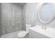 Updated bathroom with glass shower, gray tile, modern fixtures at 11343 W Mccaslin Rose Ln, Surprise, AZ 85378
